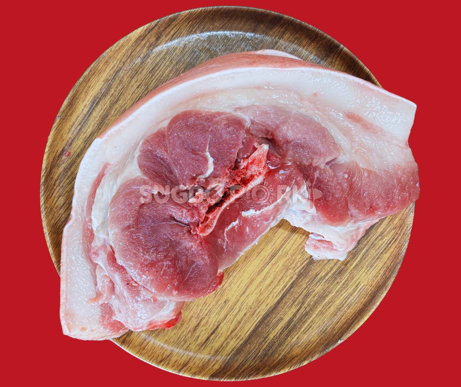 Professional product photography showing fresh pork shoulder kasim cut on wooden circular cutting board with visible marbling and Sugbo Pork watermark against vibrant red background
